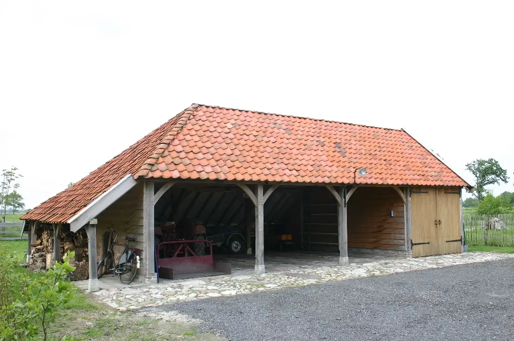 Eiken bijgebouw met drie carports en houtstek